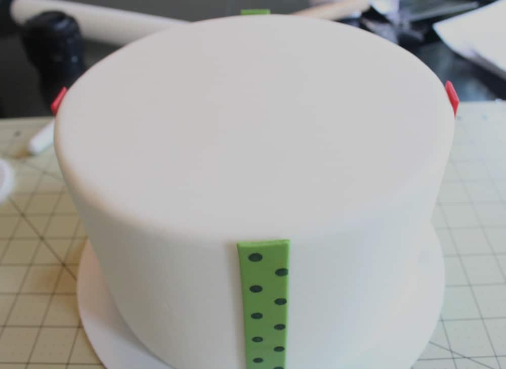 attaching second strip of fondant to cake